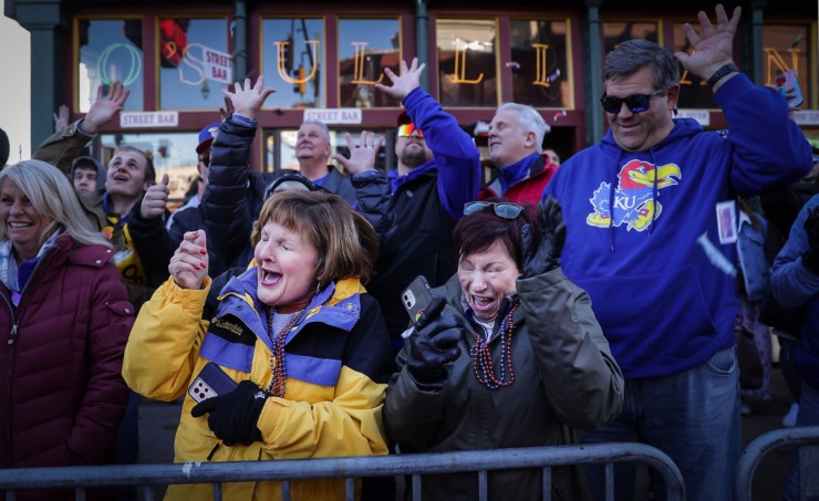 <strong>Kansas fans Linda Beaver (left) and Peggy Mueller dodge airborne candy during the 2022 AutoZone Liberty Bowl Parade on Beale Street on Dec. 27, 2022.</strong> (Patrick Lantrip/The Daily Memphian)