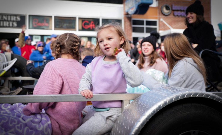 <strong>A child on a float tries to toss a bag of candy to the crowd during the 2022 AutoZone Liberty Bowl Parade on Beale Street on Dec. 27, 2022.</strong> (Patrick Lantrip/The Daily Memphian)