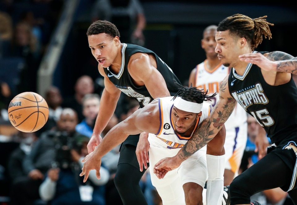 <strong>Memphis Grizzlies defenders Desmond Bane (left) and Brandon Clarke (right) battle Phoenix Suns forward Josh Okogie (middle) for a loose ball on Tuesday, Dec. 27, 2022.</strong> (Mark Weber/The Daily Memphian)