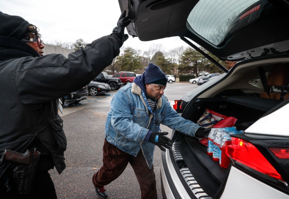<strong>Memphis Light, Gas and Water employees Audrey Summers (left) and Ronald Shotwell hand out cases of bottled water to MLGW customers on Monday, Dec. 26, 2022.</strong>&nbsp;(Mark Weber/The Daily Memphian)