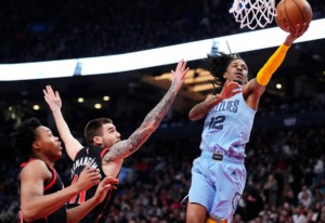 <strong>Memphis Grizzlies guard Ja Morant (12) drives to the basket past Toronto Raptors forward Scottie Barnes (4) and forward Juancho Hernangomez (41) on Thursday, Dec. 29, 2022, in Toronto.</strong> (Frank Gunn/The Canadian Press via AP)