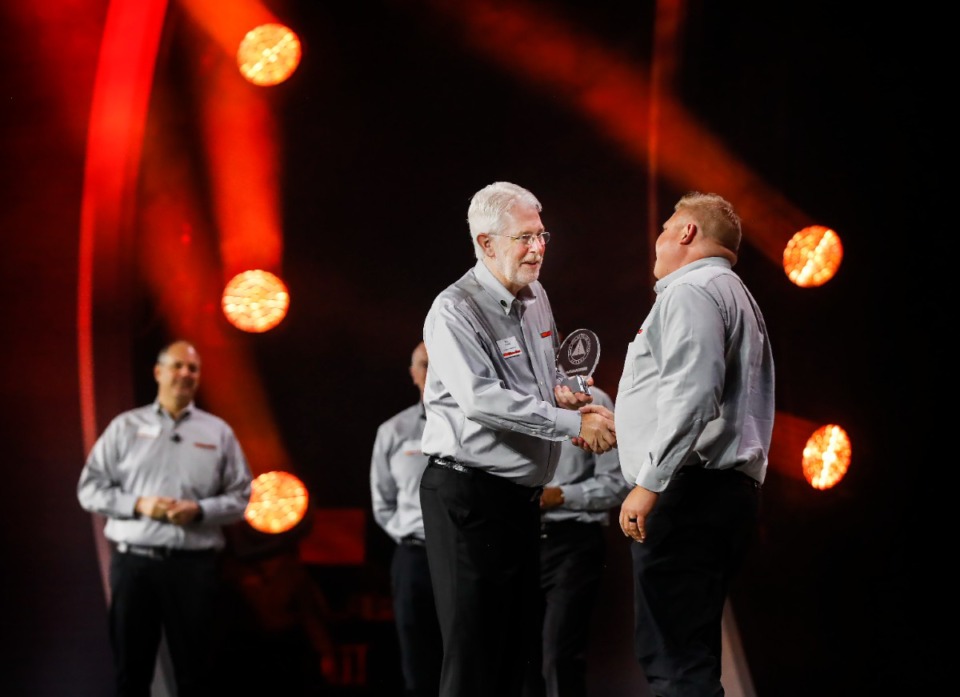 <strong>AutoZone President and CEO William C. Rhodes III (middle) hands out an employee award during the company&rsquo;s annual National Sales Meeting on Thursday, Sept. 22, 2022 at the Renasant Convention Center.</strong> (Mark Weber/The Daily Memphian file)