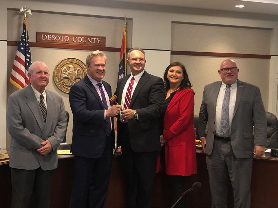 <strong>District 5 Supervisor Michael Lee (center) hands off the gavel to incoming board president and District 3 Supervisor Ray Denison (second from left) on Tuesday, Jan. 3. DeSoto County Board of Supervisors also appointed District 4 Supervisor Lee Caldwell (second from right) as vice president at Tuesday&rsquo;s meeting. They are pictured with District 1 Supervisor Jessie Medlin (far left) and District 2 Supervisor Mark Gardner (far right).</strong> (Beth Sullivan/The Daily Memphian)