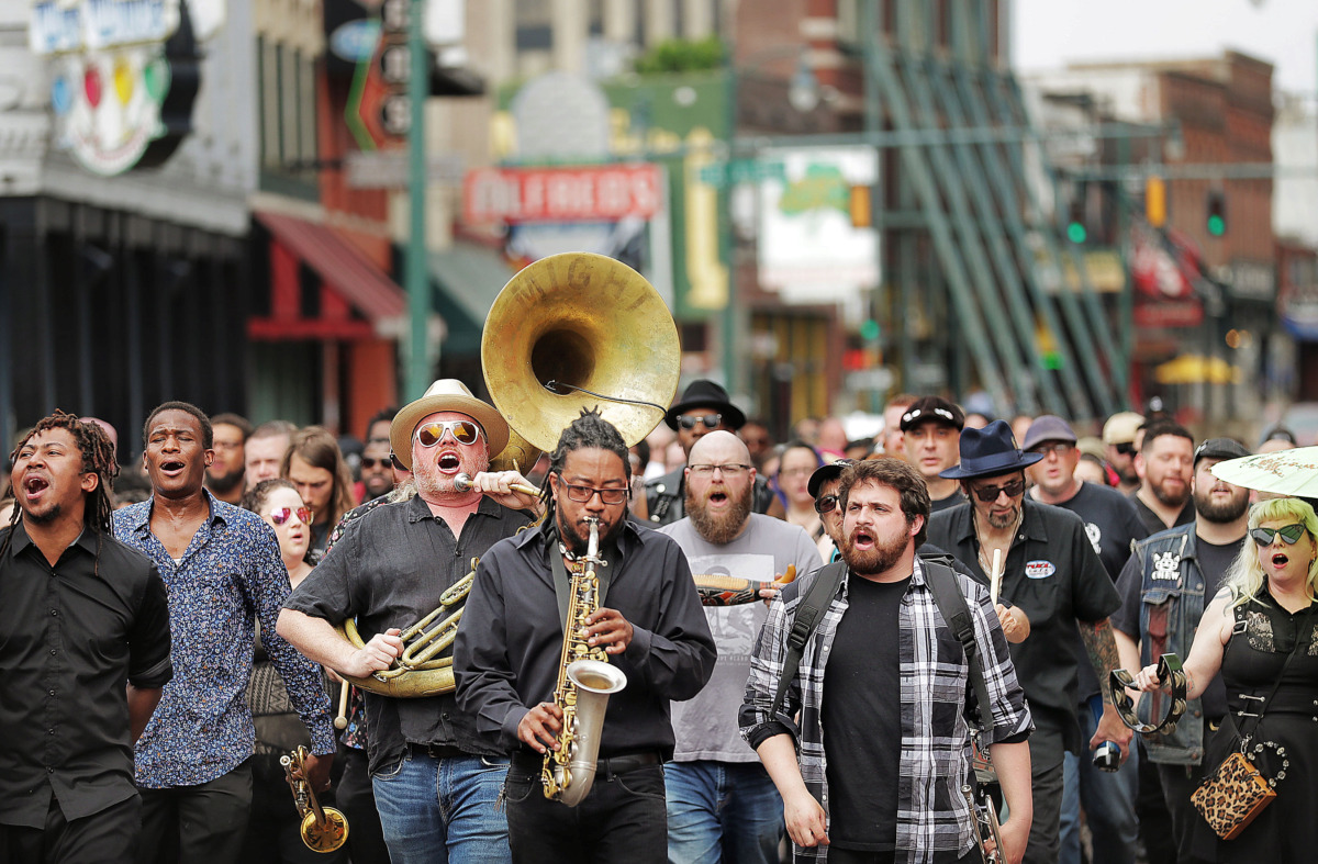 <strong>Local musicians, fans, friends and family sing "When the Saints Go Marching In" as they march in a Beale Street funeral procession to honor Memphis musician Omar Higgins. A crowd led Higgins' casket on April 30, 2019, second-line style to Clayborn Temple for a visitation and funeral service.</strong> (Jim Weber/Daily Memphian)
