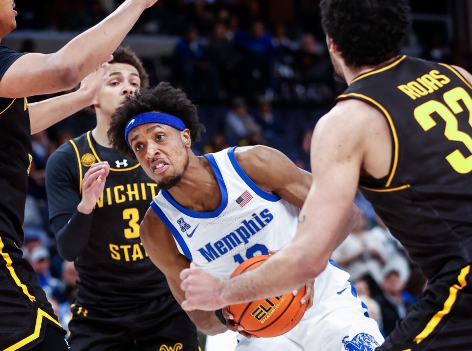 <strong>Tigers forward DeAndre Williams (middle) drives the lane against the Wichita State defense during action on Thursday, Jan. 19, 2023.</strong> (Mark Weber/The Daily Memphian)