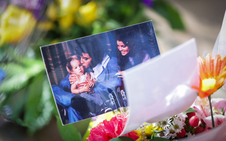 <strong>A photo of a young Lisa Marie Presley with her parents sits atop a bouquet of flowers at Graceland.</strong> (Patrick Lantrip/The Daily Memphian)