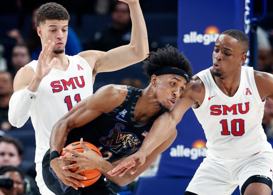 <strong>Tigers forward DeAndre Williams (middle) grabs a rebound in front of SMU defenders Samuell Williamson (left) and Zach Nutall (right) on Thursday, Jan. 26, 2023.</strong> (Mark Weber/The Daily Memphian)