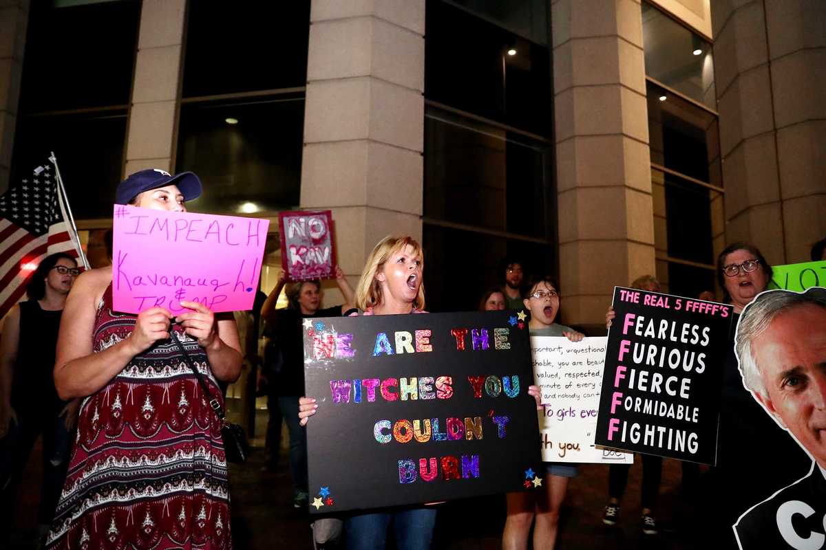 <strong>Diana Chabot (center) joins other protestors at the corner of Main Street and Peabody Place Monday to protest the confirmation of Judge Brett Kavanaugh as a U.S. Supreme Court justice.</strong> (Houston Cofield/Daily Memphian)