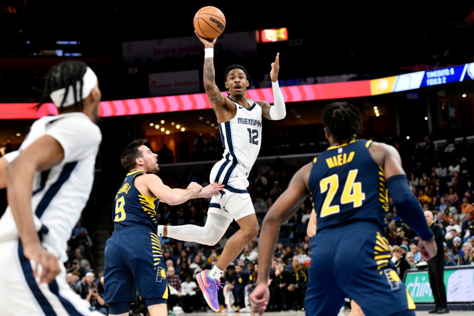 <strong>Memphis Grizzlies guard Ja Morant (12) passes the ball over Indiana Pacers guard T.J. McConnell (9) in the first half of an NBA basketball game Sunday, Jan. 29, 2023, in Memphis, Tenn.</strong> (AP Photo/Brandon Dill)
