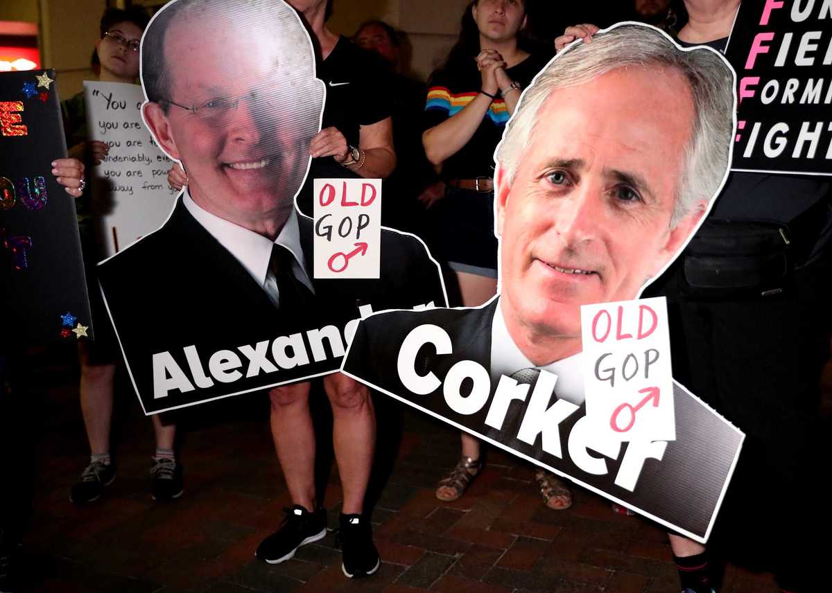 <strong>Protesters of Judge Brett Kavanaugh's confirmation to the U.S. Supreme Court hold signs depicting Sens. Lamar Alexander and Bob Corker, who were among the 50-48 majority who voted in favor of Kavanaugh.</strong> (Houston Cofield/Daily Memphian)