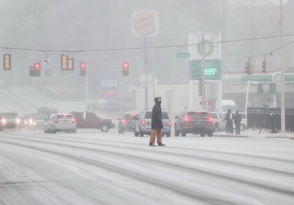 <strong>A pedestrian crosses Poplar Avenue as freezing rain falls on Tuesday, Jan. 31.</strong> (Mark Weber/The Daily Memphian)
